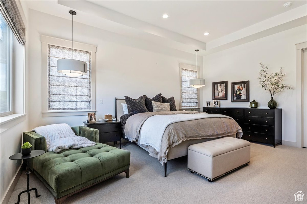 Bedroom with light colored carpet, multiple windows, and recessed lighting