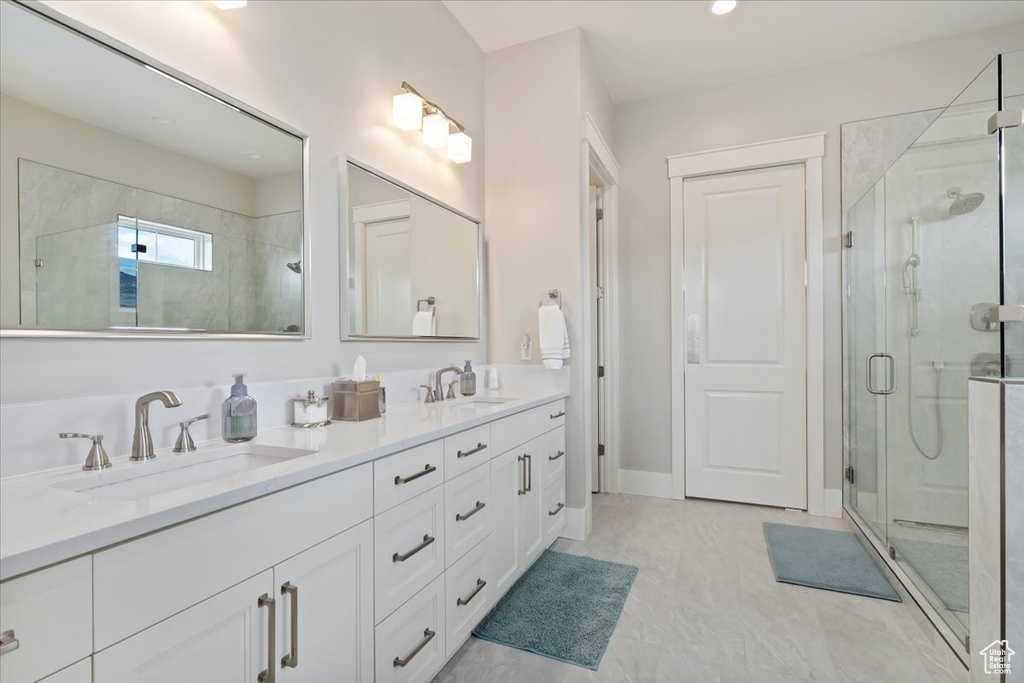 Full bathroom featuring a stall shower, double vanity, and recessed lighting