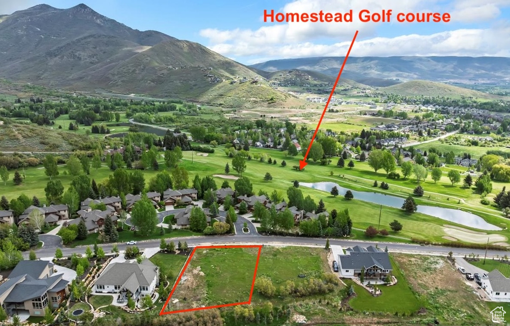Aerial perspective of suburban area with property parcel outlined, a water and mountain view, and a local golf course