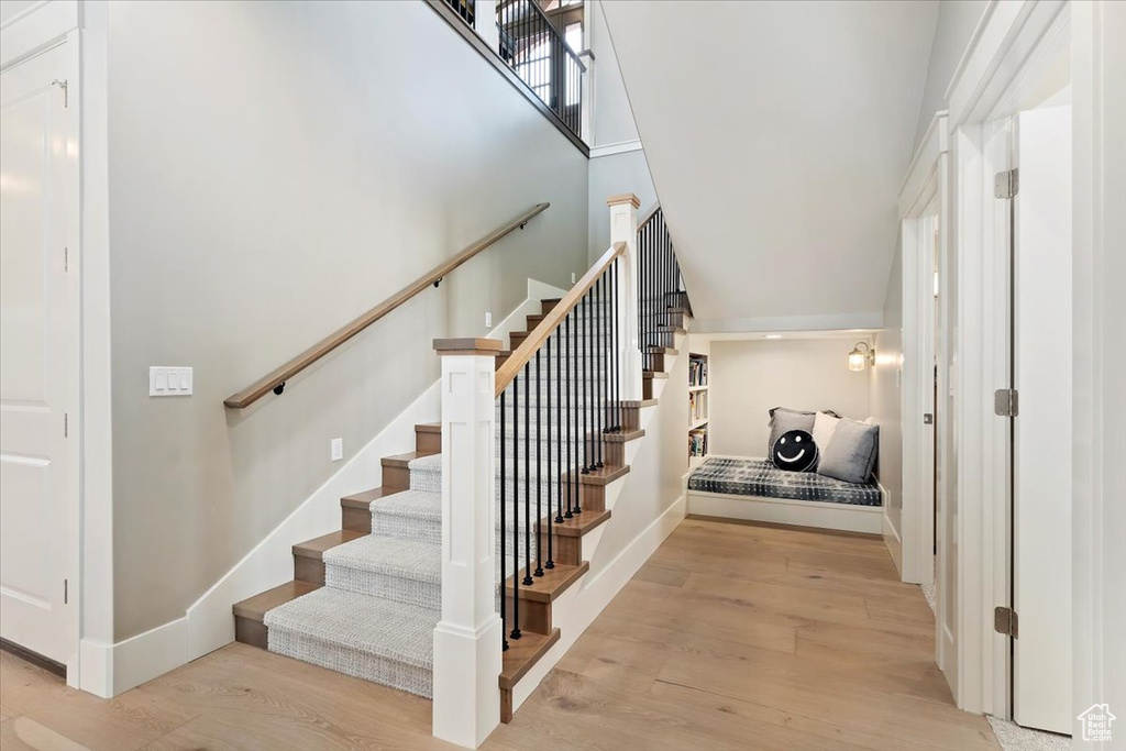 Stairway featuring wood finished floors and a high ceiling