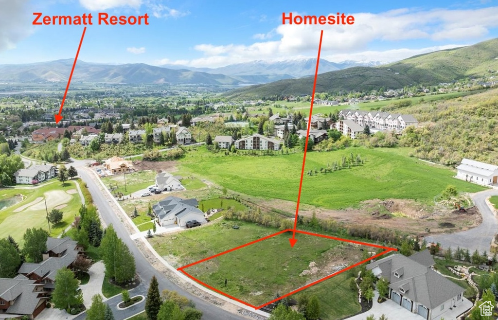 Aerial perspective of suburban area with property parcel outlined and a mountain backdrop