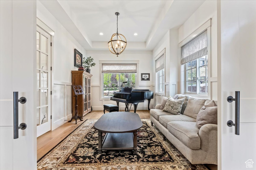 Entryway featuring light wood finished floors, a chandelier, recessed lighting, and a raised ceiling
