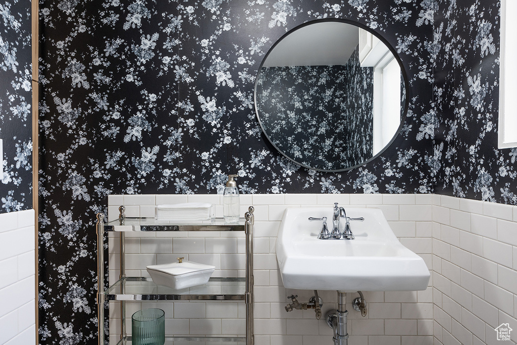 Bathroom featuring wallpapered walls and a sink