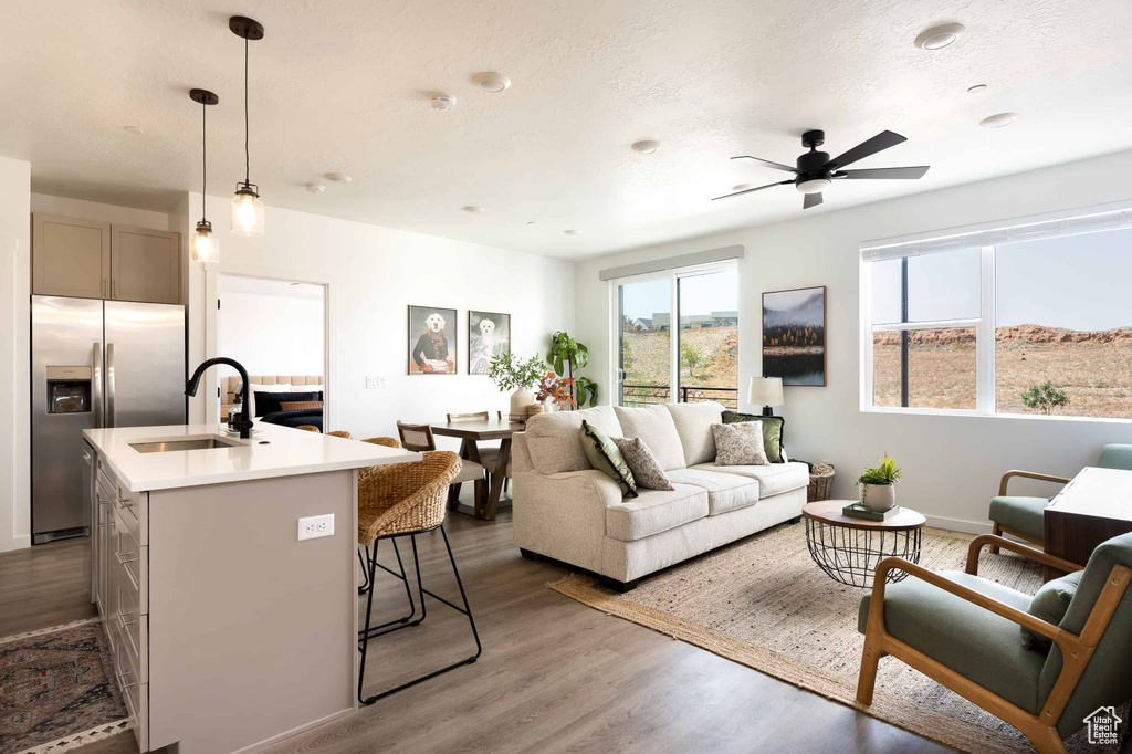 Living area featuring ceiling fan and dark wood-type flooring