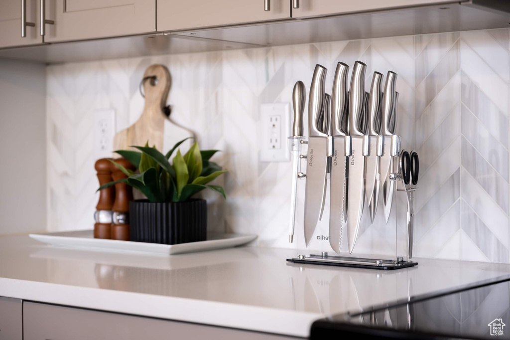 Kitchen view of light countertops, gray cabinets, and backsplash
