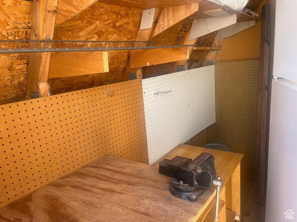 Below grade area featuring freestanding refrigerator and wood finished floors