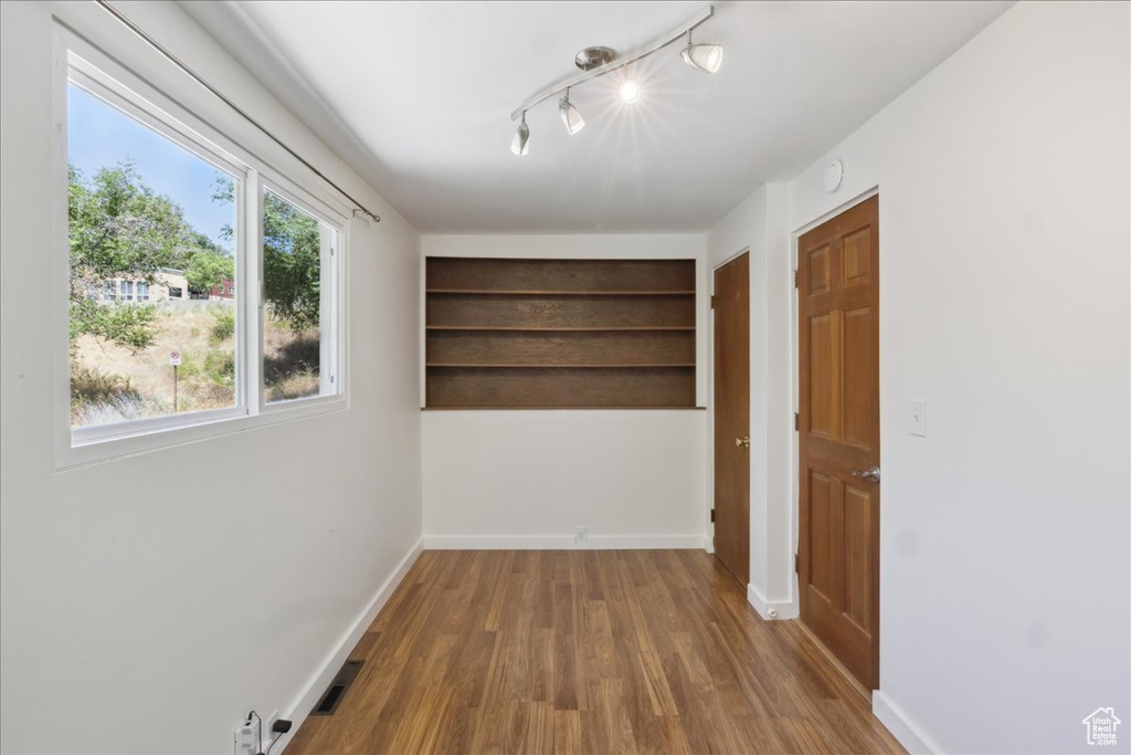 Spare room featuring wood finished floors and rail lighting