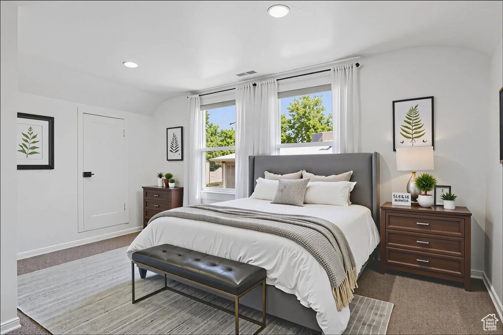 Carpeted bedroom with recessed lighting and vaulted ceiling