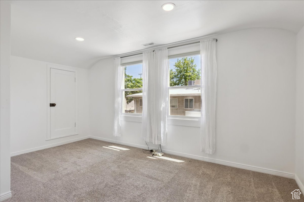Carpeted spare room with lofted ceiling and recessed lighting
