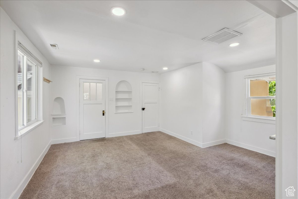 Carpeted empty room with recessed lighting and built in features