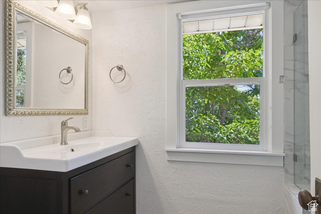 Full bathroom featuring vanity and a textured wall