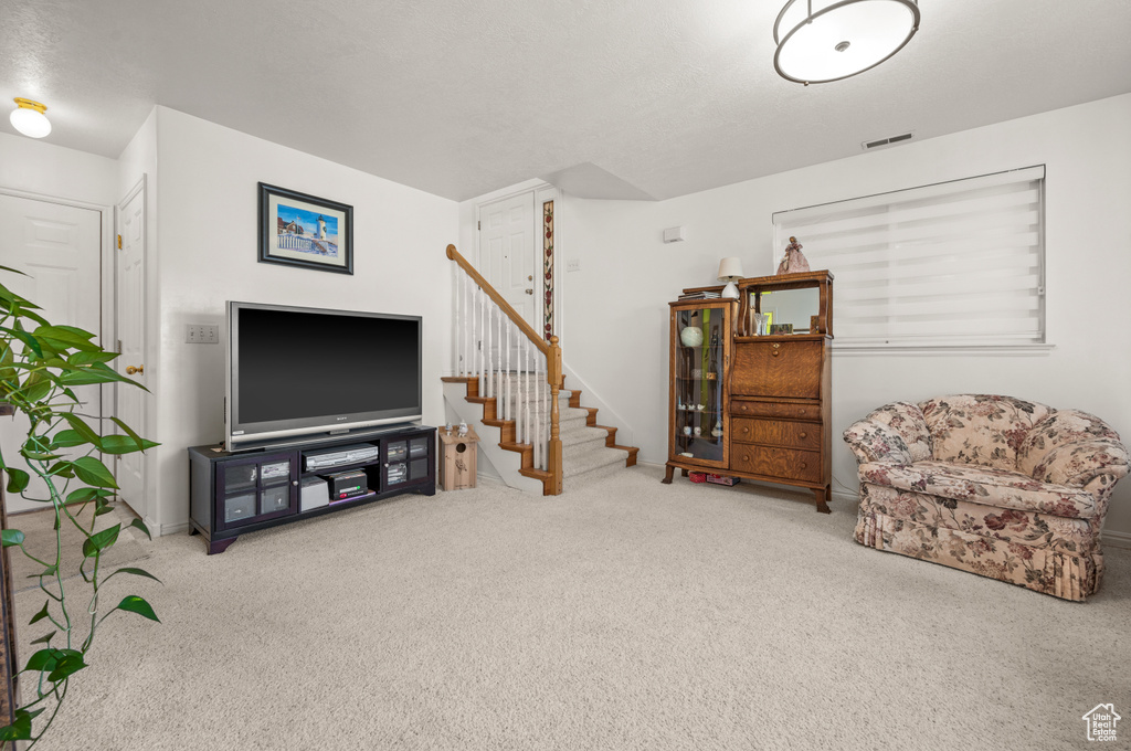 Living room featuring carpet flooring and stairway