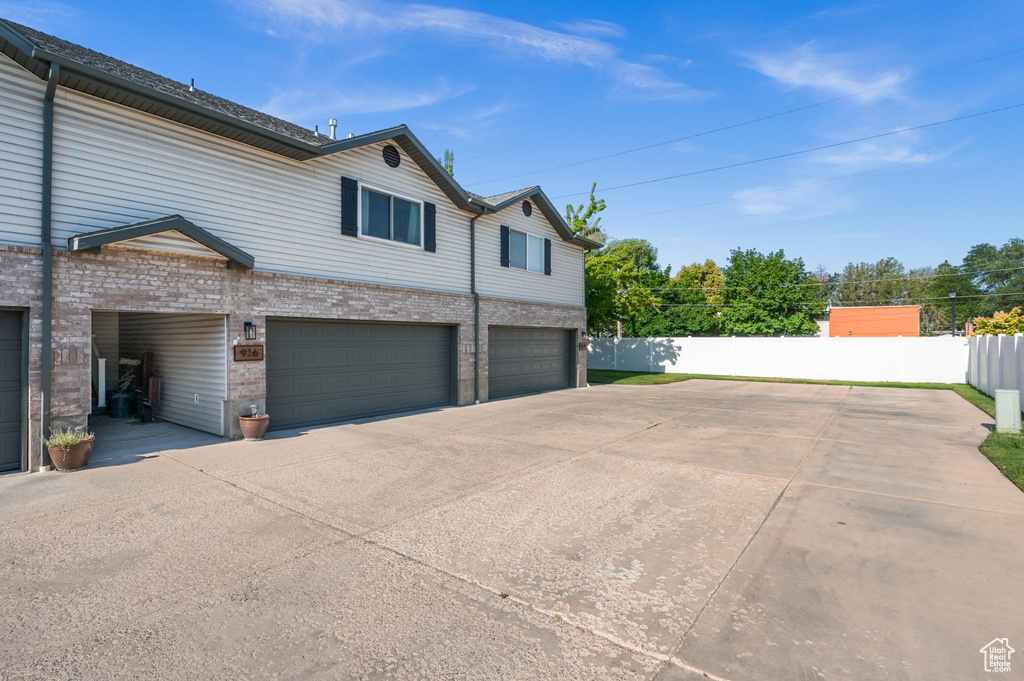 View of home\'s exterior with brick siding, a garage, and driveway