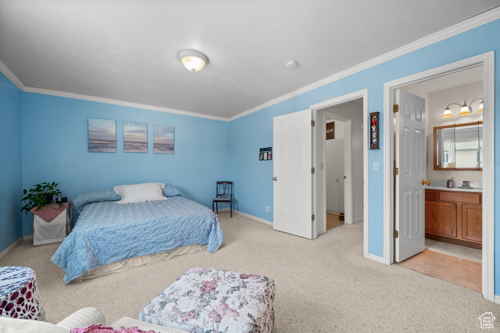 Bedroom featuring light colored carpet, crown molding, and ensuite bathroom