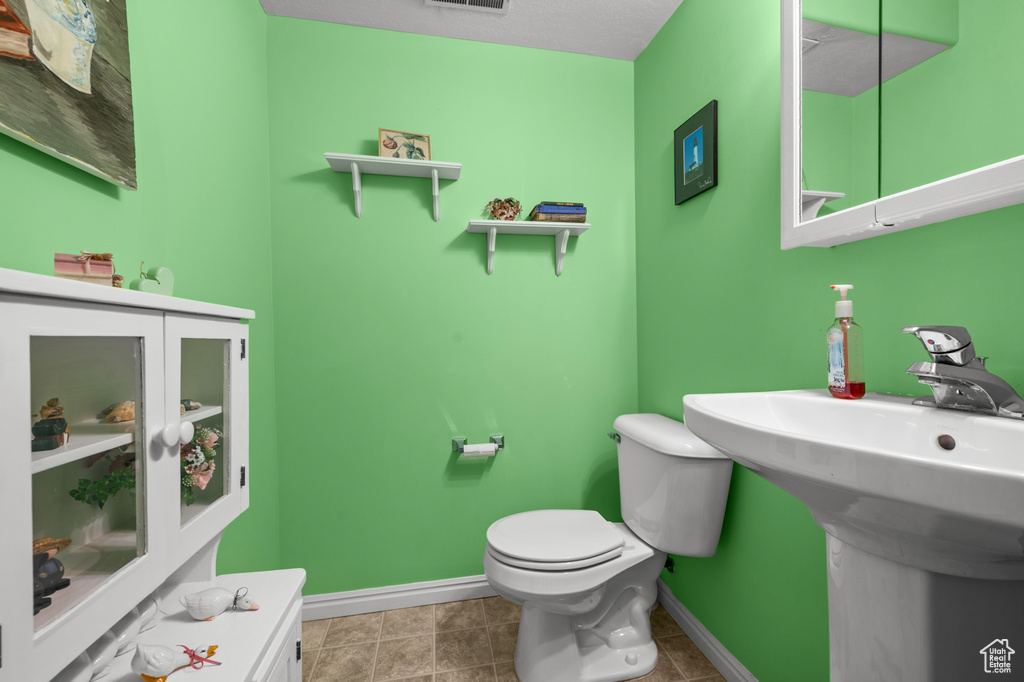 Half bathroom featuring baseboards and toilet