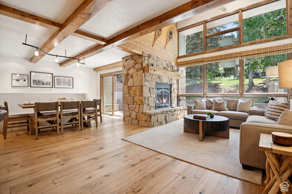 Living room featuring beamed ceiling, hardwood / wood-style floors, and a fireplace