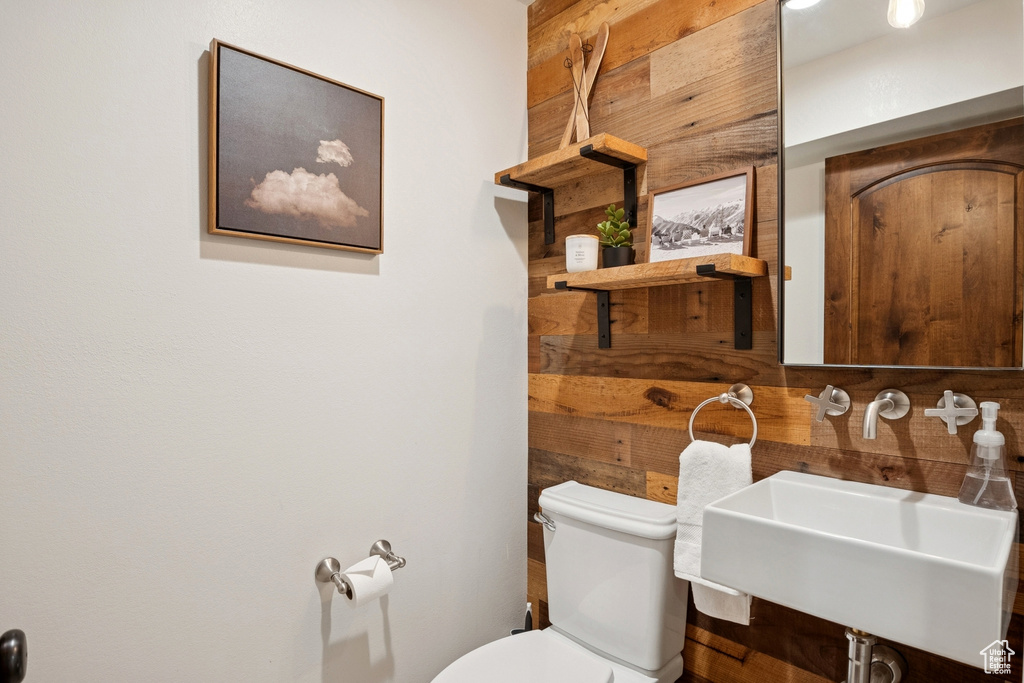 Half bath with toilet and wood walls
