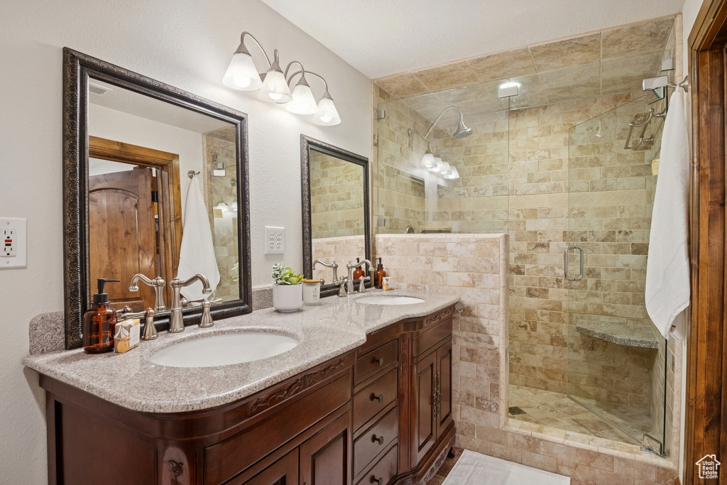 Full bathroom featuring a stall shower and double vanity