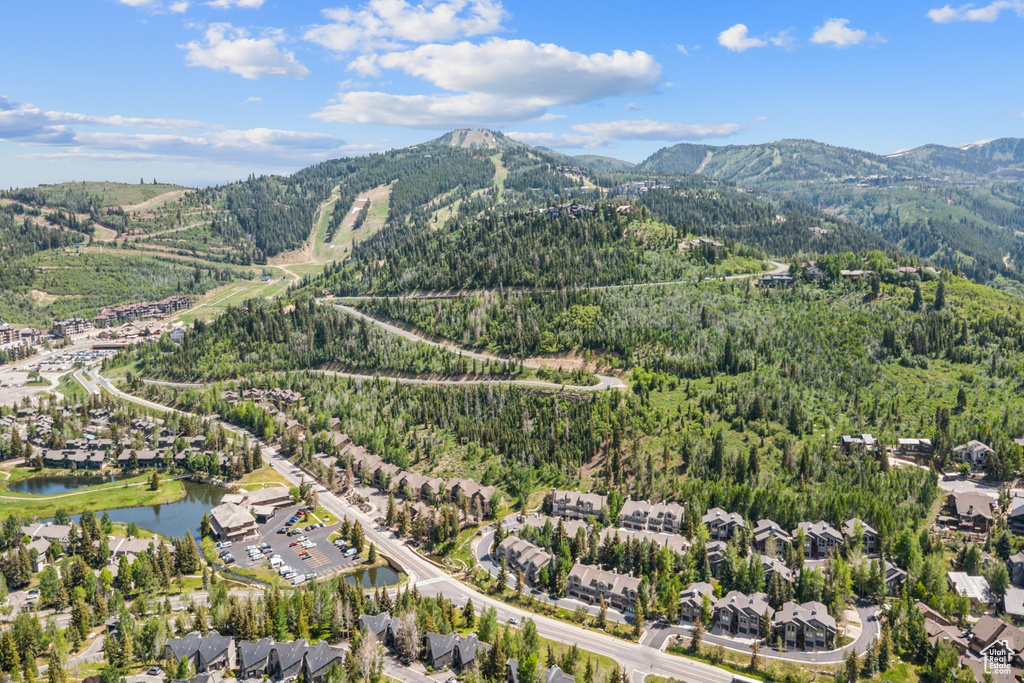 Aerial view of property and surrounding area with a heavily wooded area and a water and mountain view