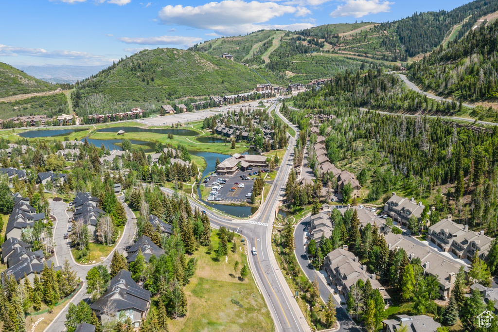Aerial view of property and surrounding area featuring a water and mountain view and nearby suburban area