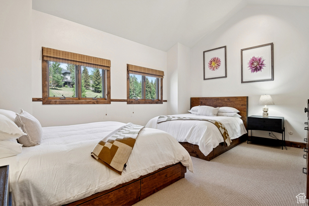 Carpeted bedroom featuring lofted ceiling