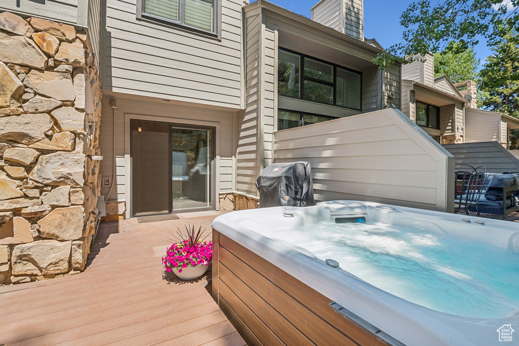 Wooden deck featuring a hot tub and grilling area