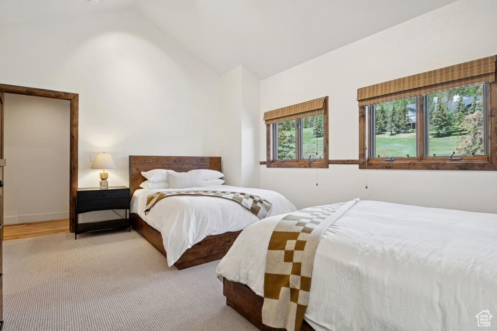 Carpeted bedroom featuring high vaulted ceiling