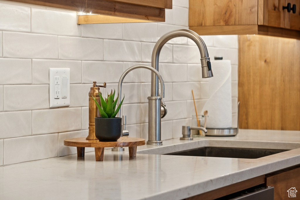 Kitchen view of light stone countertops and decorative backsplash