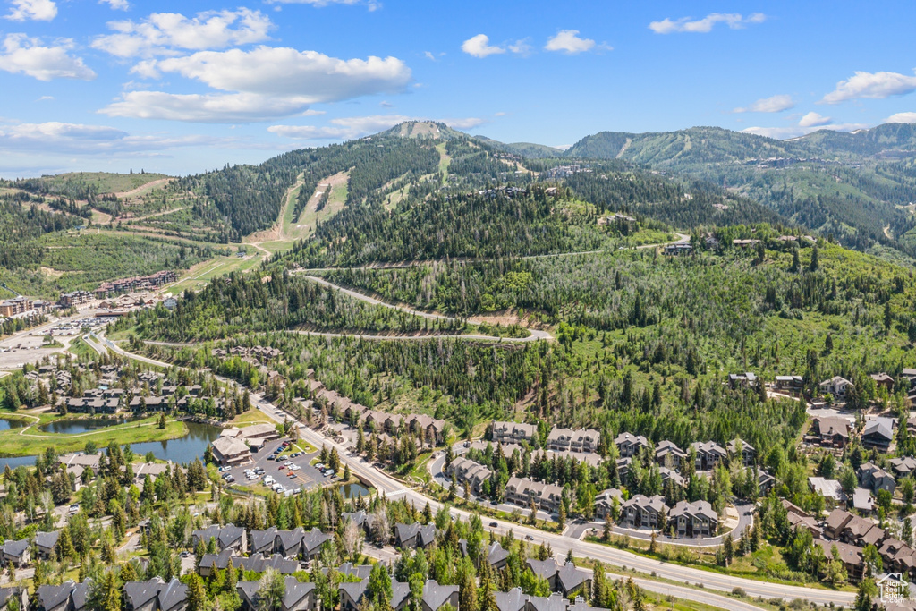Aerial view of property and surrounding area featuring a water and mountain view and nearby suburban area