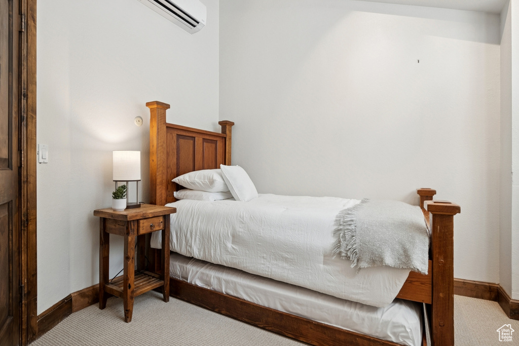 Bedroom featuring light carpet and a wall mounted AC