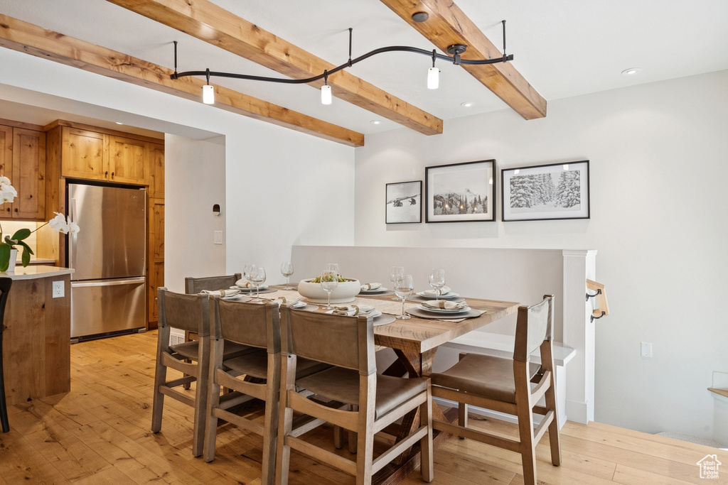 Dining area with beam ceiling, light wood-style flooring, and recessed lighting