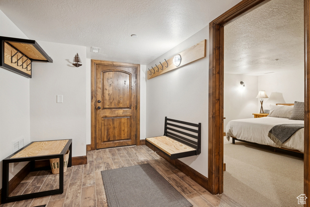 Entryway with a textured ceiling and light wood-type flooring
