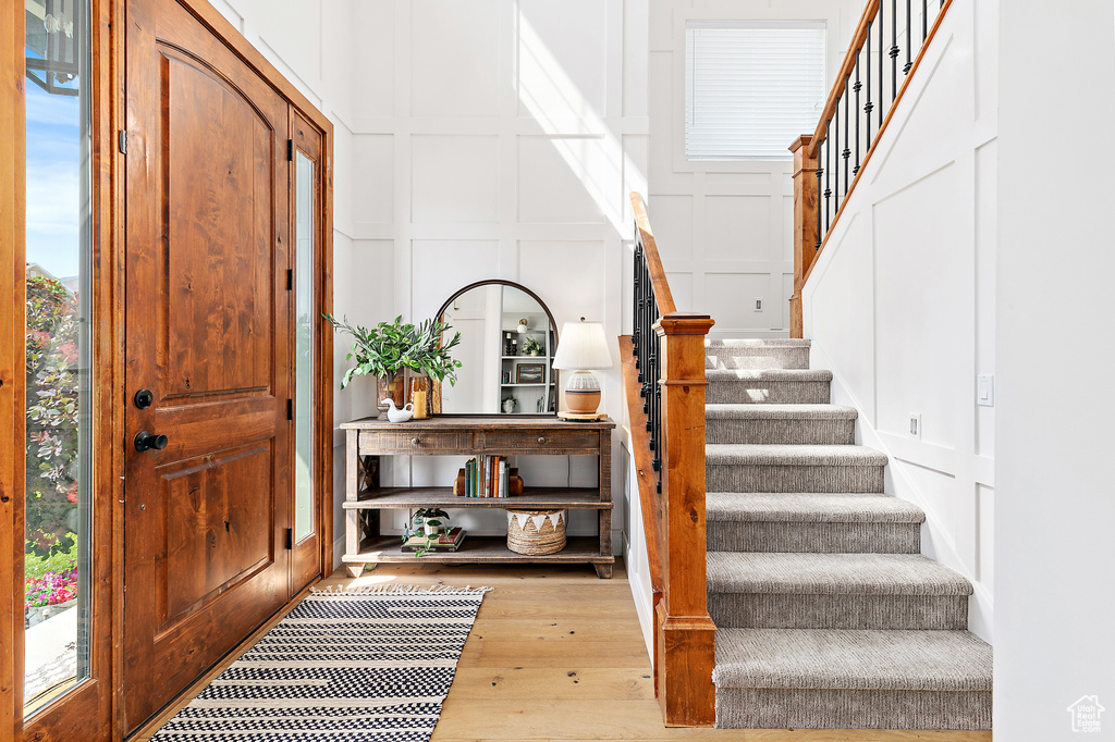 Foyer with a decorative wall, stairway, and hardwood / wood-style flooring