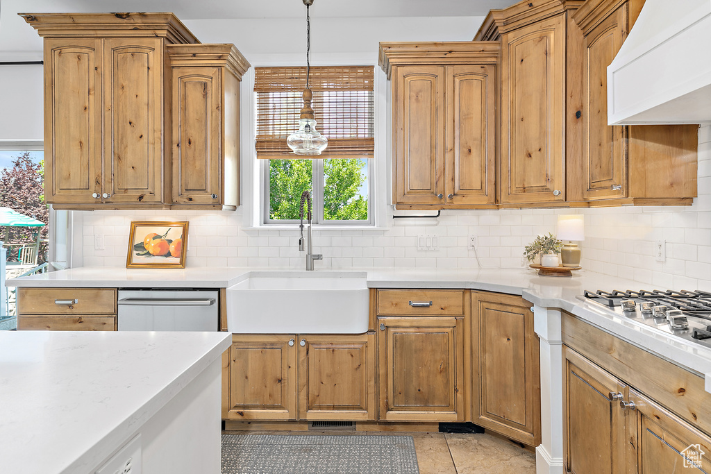 Kitchen with custom exhaust hood, light countertops, and decorative backsplash