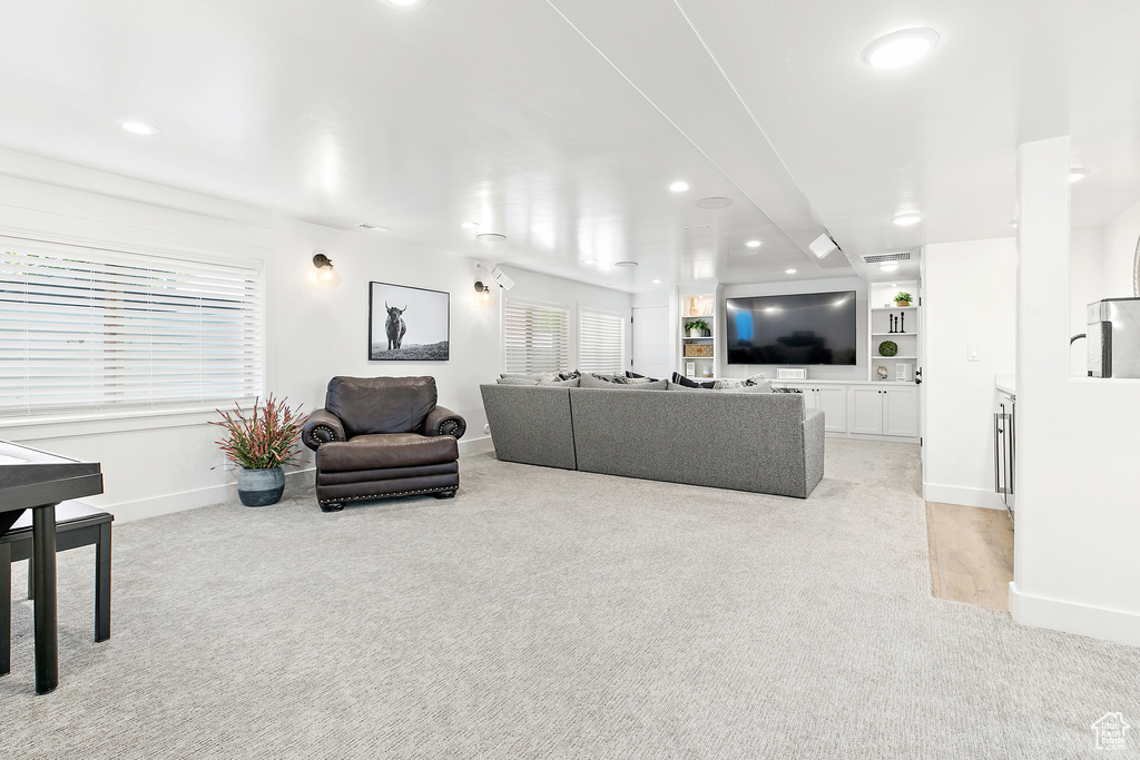 Living area with light colored carpet and recessed lighting