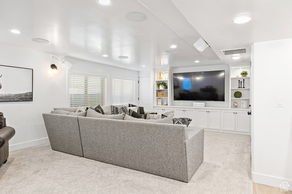 Living area featuring light colored carpet and recessed lighting