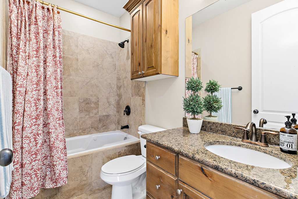 Bathroom featuring shower / tub combo with curtain and vanity