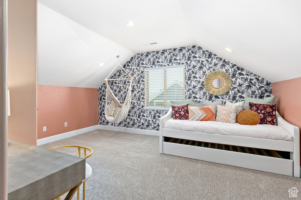 Carpeted bedroom featuring vaulted ceiling and wallpapered walls