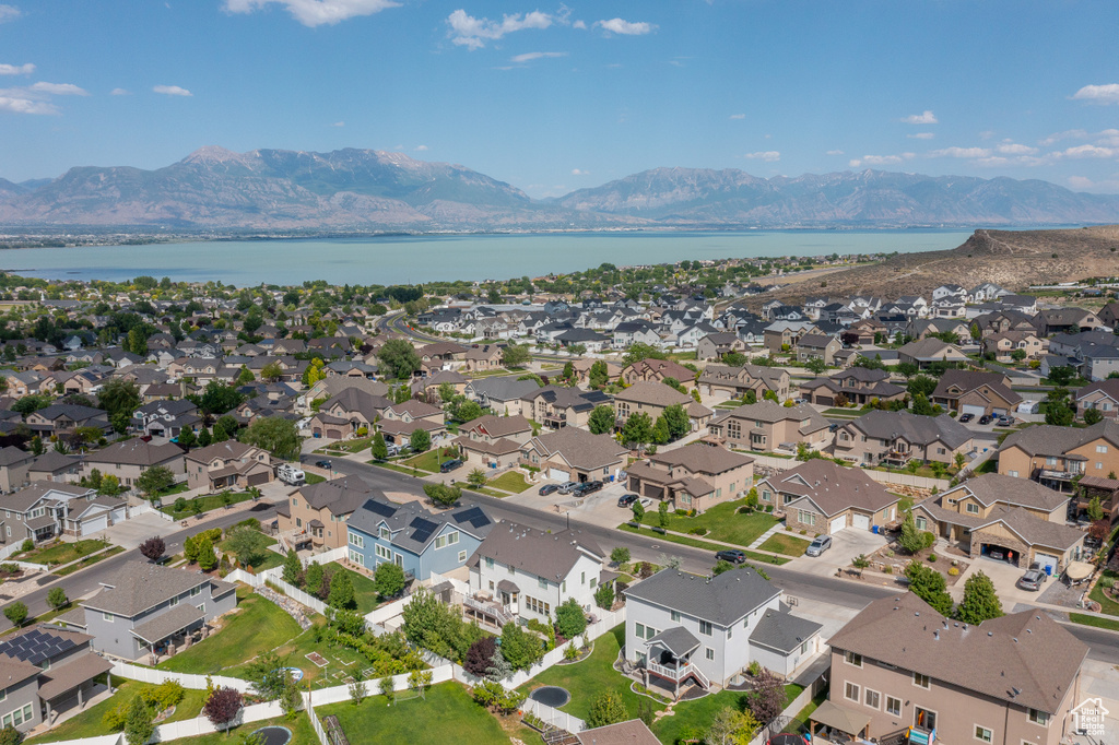 Aerial view of property and surrounding area featuring a water and mountain view and nearby suburban area