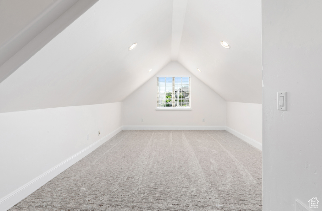 Additional living space featuring vaulted ceiling, light carpet, and recessed lighting