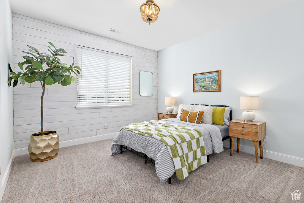 Bedroom featuring carpet flooring and wooden walls