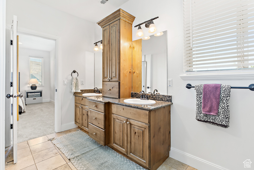 Full bath featuring double vanity and tile patterned floors