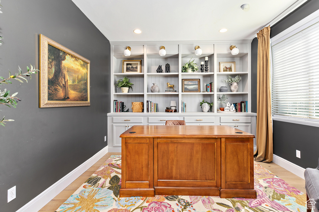 Home office with light wood-style flooring and recessed lighting