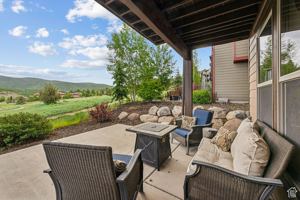 View of patio / terrace featuring a mountain view and an outdoor living space with a fire pit