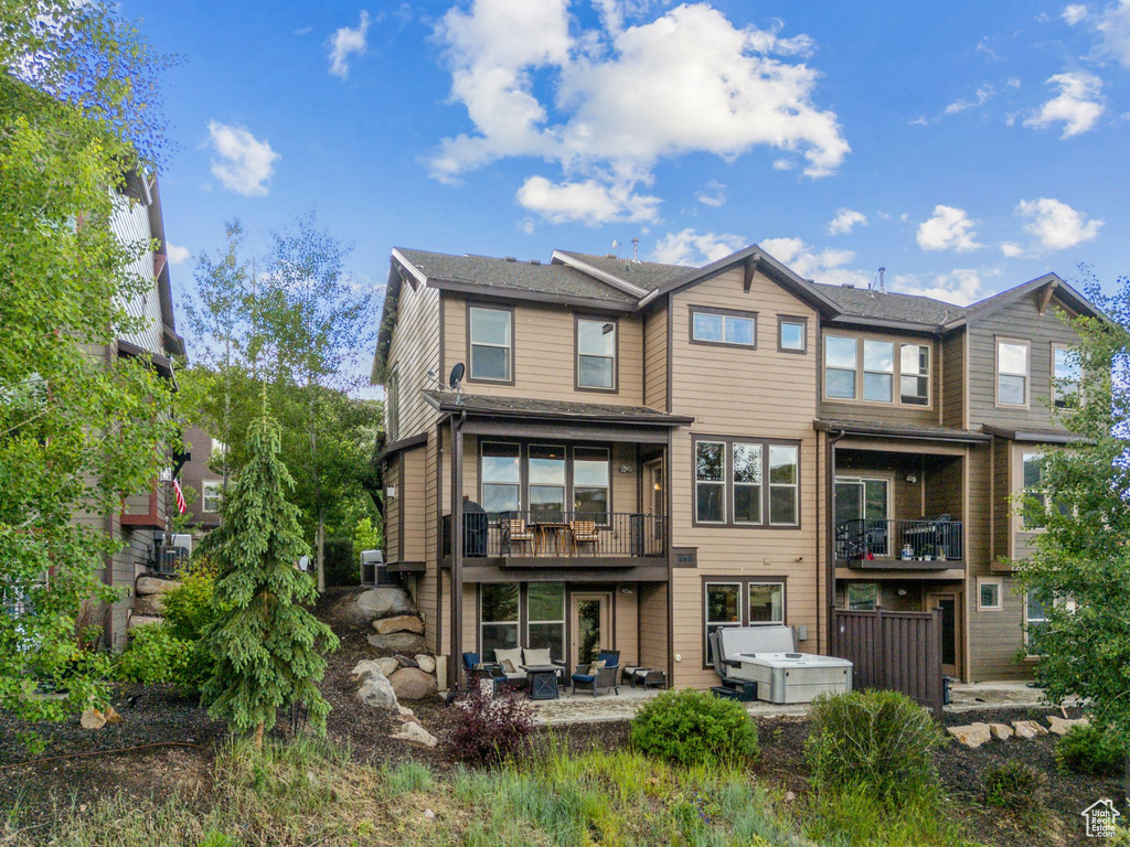 Rear view of house featuring an outdoor hangout area, a patio, and a balcony