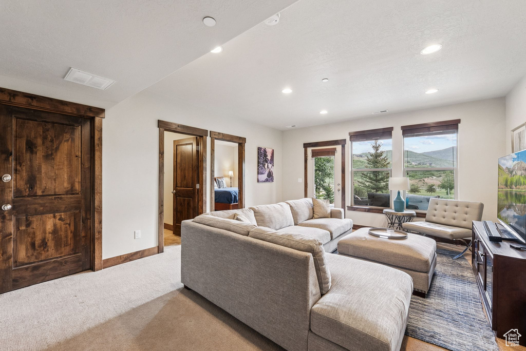 Living room with light carpet and recessed lighting