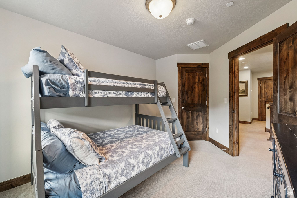 Carpeted bedroom with baseboards and a textured ceiling