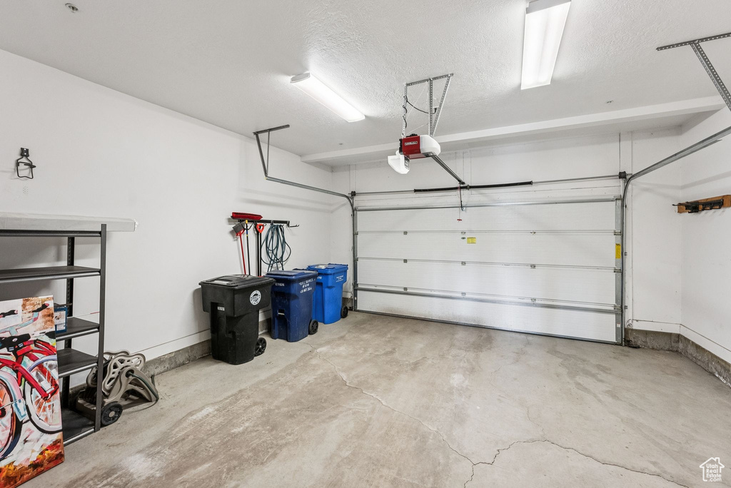 Garage with a garage door opener and baseboards