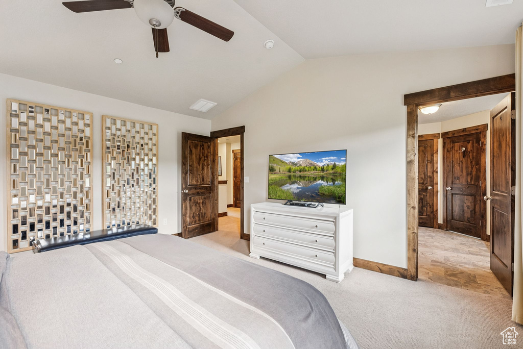 Carpeted bedroom with vaulted ceiling and a ceiling fan