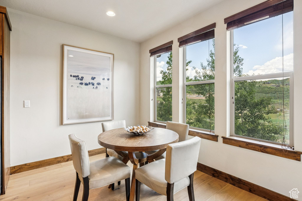 Dining space with light wood-style floors and recessed lighting